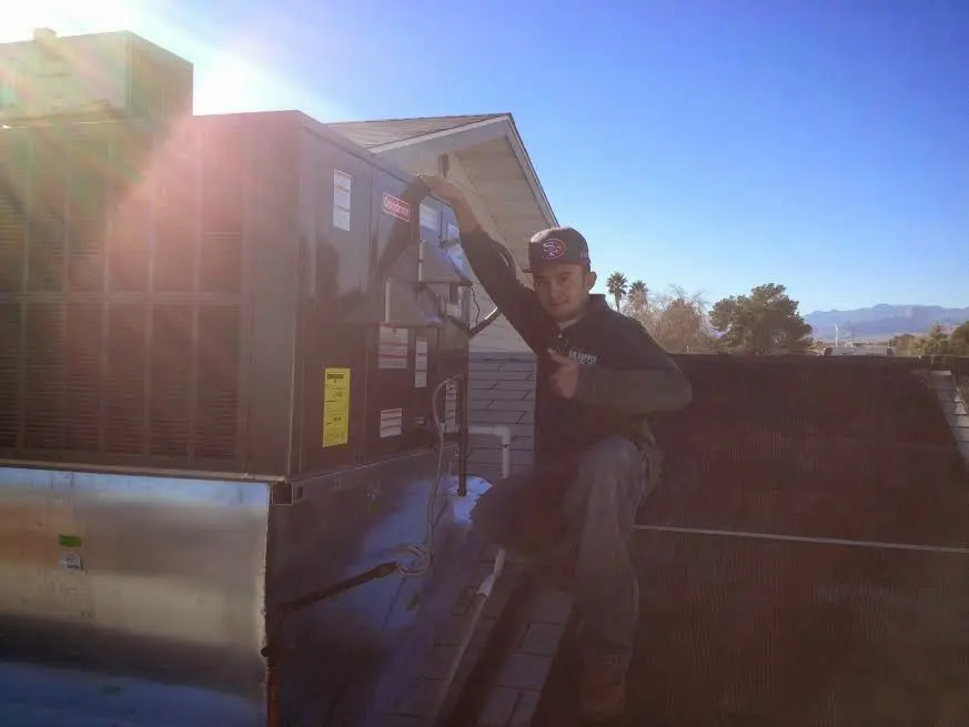 HVAC technician performing AC Tune-Up on a rooftop unit in McGregor